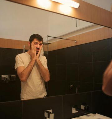 Exhausted man researching supplements to combat fatigue and boost energy levels